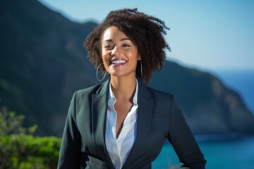 Poster - Portrait of a cheerful afro-american woman in her 30s wearing a professional suit jacket isolated on dramatic coastal cliff background