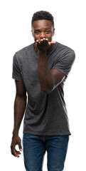 Sticker - Young african american man wearing grey t-shirt looking at the camera blowing a kiss with hand on air being lovely and sexy. Love expression.