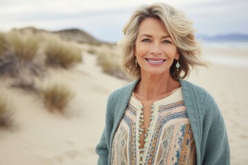 Wall Mural - Portrait of a cheerful woman in her 50s wearing a chic cardigan in front of serene dune landscape background