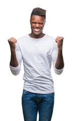 Canvas Print - Young african american man over isolated background celebrating surprised and amazed for success with arms raised and open eyes. Winner concept.