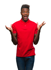 Wall Mural - Young african american man over isolated background celebrating crazy and amazed for success with arms raised and open eyes screaming excited. Winner concept