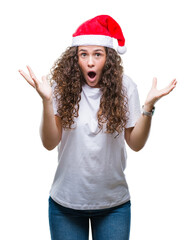 Sticker - Young brunette girl wearing christmas hat over isolated background celebrating crazy and amazed for success with arms raised and open eyes screaming excited. Winner concept