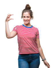 Poster - Beautiful brunette curly hair young girl wearing casual look over isolated background smiling and confident gesturing with hand doing size sign with fingers while looking and the camera