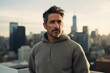 © Markus Schröder - Portrait of a blissful man in his 40s dressed in a comfy fleece pullover in front of modern cityscape background