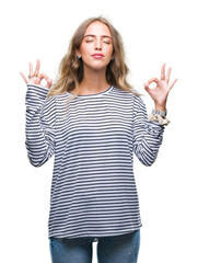 Poster - Beautiful young blonde woman wearing stripes sweater over isolated background relax and smiling with eyes closed doing meditation gesture with fingers. Yoga concept.