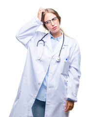 Wall Mural - Beautiful young blonde doctor woman wearing medical uniform over isolated background confuse and wonder about question. Uncertain with doubt, thinking with hand on head. Pensive concept.