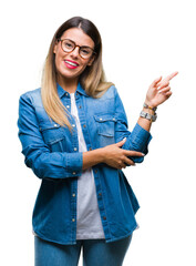 Wall Mural - Young beautiful woman over wearing glasses over isolated background with a big smile on face, pointing with hand and finger to the side looking at the camera.