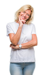 Poster - Middle age blonde woman over isolated background looking confident at the camera with smile with crossed arms and hand raised on chin. Thinking positive.