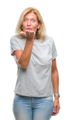 Poster - Middle age blonde woman over isolated background looking at the camera blowing a kiss with hand on air being lovely and sexy. Love expression.