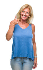 Poster - Middle age blonde woman over isolated background doing happy thumbs up gesture with hand. Approving expression looking at the camera with showing success.