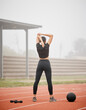 © Siphosethu/peopleimages.com - Woman, back and stretching arms at stadium, runner and training in outdoor fitness or workout. Female person, warm up or sports athlete getting ready for wellness, performance or mobility on track