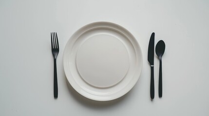 Wall Mural - Plate with utensils on white background from above