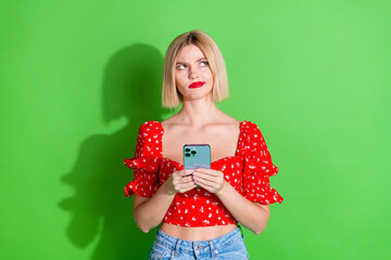 Wall Mural - Photo of minded lovely cute woman wear red stylish clothes look poster empty space isolated on green color background