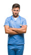 © Krakenimages.com - Young handsome doctor nurse man over isolated background skeptic and nervous, disapproving expression on face with crossed arms. Negative person.