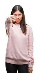 Poster - Young beautiful hispanic woman wearing a sweater looking unhappy and angry showing rejection and negative with thumbs down gesture. Bad expression.