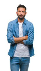 Wall Mural - Adult hispanic man over isolated background skeptic and nervous, disapproving expression on face with crossed arms. Negative person.