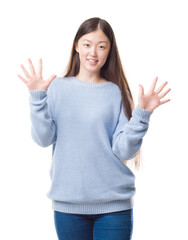 Sticker - Young Chinese woman over isolated background showing and pointing up with fingers number ten while smiling confident and happy.