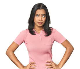 Wall Mural - simple portrait of a young latina confused, feels doubtful and unsure.