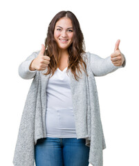 Beautiful plus size young woman wearing winter jacket over isolated background approving doing positive gesture with hand, thumbs up smiling and happy for success. Looking at the camera.