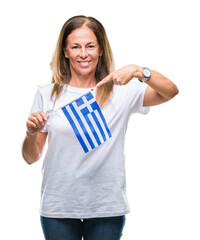 Canvas Print - Middle age hispanic woman holding flag of Greece over isolated background very happy pointing with hand and finger