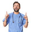 © Asier - Hispanic male nurse in studio pointing upside with opened mouth.