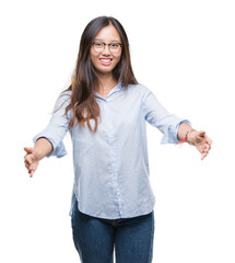 Poster - Young asian business woman wearing glasses over isolated background looking at the camera smiling with open arms for hug. Cheerful expression embracing happiness.