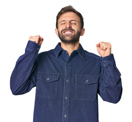 Studio portrait of young Hispanic male celebrating a victory, passion and enthusiasm, happy expression.