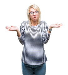 Sticker - Young beautiful blonde woman wearing glasses over isolated background clueless and confused expression with arms and hands raised. Doubt concept.