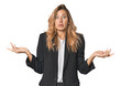 © Asier - Young businesswoman in a suit doubting and shrugging shoulders in questioning gesture.