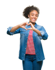 Wall Mural - Young afro american woman over isolated background smiling in love showing heart symbol and shape with hands. Romantic concept.