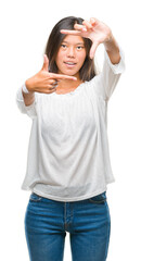 Canvas Print - Young asian woman over isolated background smiling making frame with hands and fingers with happy face. Creativity and photography concept.