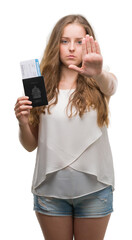 Poster - Young blonde woman holding passport of canada and boarding pass with open hand doing stop sign with serious and confident expression, defense gesture