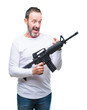 © Krakenimages.com - Middle age senior hoary criminal man holding gun weapon over isolated background very happy pointing with hand and finger