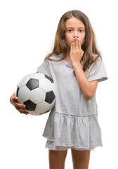 Poster - Brunette hispanic girl holding soccer football ball cover mouth with hand shocked with shame for mistake, expression of fear, scared in silence, secret concept