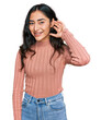 © Krakenimages.com - Hispanic teenager girl with dental braces wearing casual clothes smiling with hand over ear listening an hearing to rumor or gossip. deafness concept.