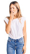 © Krakenimages.com - Beautiful caucasian woman with blonde hair wearing casual white tshirt bored yawning tired covering mouth with hand. restless and sleepiness.