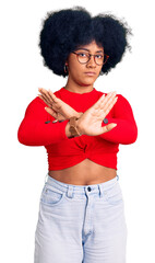 Canvas Print - Young african american girl wearing casual clothes and glasses rejection expression crossing arms doing negative sign, angry face