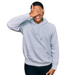 © Krakenimages.com - Young handsome hispanic man wearing casual sweatshirt smiling and laughing with hand on face covering eyes for surprise. blind concept.