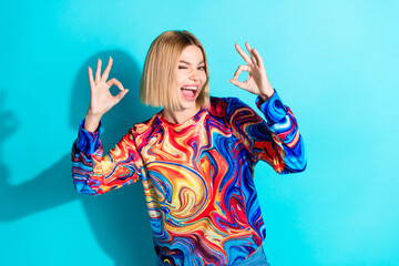 Poster - Photo of satisfied nice girl with bob hairstyle dressed print shirt showing okey winking eye isolated on turquoise color background