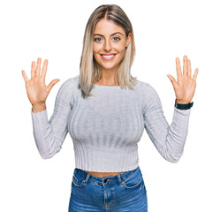 Wall Mural - Beautiful blonde woman wearing casual clothes showing and pointing up with fingers number ten while smiling confident and happy.