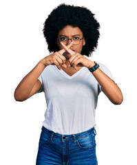 Poster - Young african american woman wearing casual white t shirt rejection expression crossing fingers doing negative sign