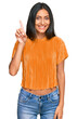 © Krakenimages.com - Young brunette arab woman wearing casual clothes showing and pointing up with finger number one while smiling confident and happy.