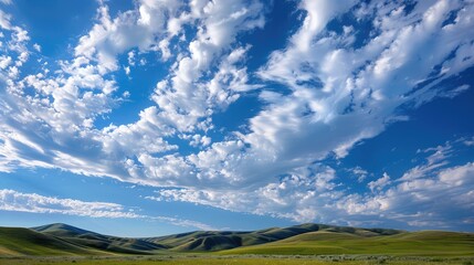 Wall Mural - A serene scene with smooth, undulating altocumulus clouds drifting gently across a brilliant blue sky over rolling hills.