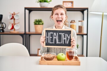 Poster - Excited young blonde woman celebrates breakfast victory at home, yes to success with healthy food on blackboard!