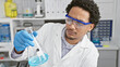 © Krakenimages.com - African american man scientist analyzing a liquid in a flask at a laboratory