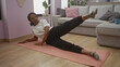 © Krakenimages.com - A young african american woman exercises on a yoga mat in her living room at home, highlighting the everyday routine of healthy living intertwined with modern interior comforts.