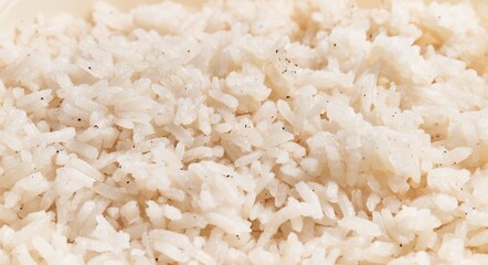 Wall Mural - Close-up of steamed white rice grains sprinkled with pepper, indicating a culinary theme and food background