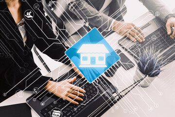 Wall Mural - Smart Home with Computer Control Concept. Businessman and businesswoman working on laptop computers at office desk with logo of smart home. uds