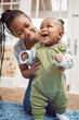 © Siphosethu/peopleimages.com - Woman, baby and development milestone with support or motor skills, care and learning in living room. Mom, kid and happiness for independent standing in home with growth, together with help for goal