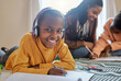© peopleimages.com - Black child, portrait smile and homework with headphones for learning, development and writing in home. African boy, happy and listening to music with education, english notes and studying for test
